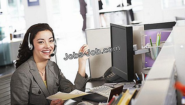 Forretningskvinde iført headset på skrivebordet, smilende, portræt