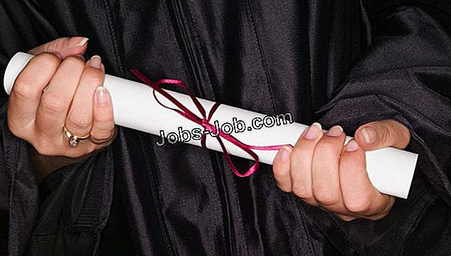 Prim-plan al unei fete care își ține diploma strâns cu ambele mâini