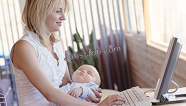 Mãe, usando computador, e, segurando bebê