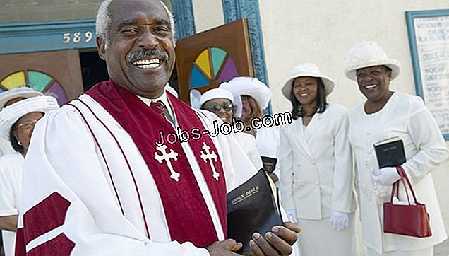 Usmievajúci sa kňaz stojaci pred zborom mimo kostola, ktorý drží Bibliu